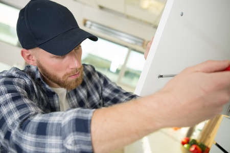 man installing a cabinetの写真素材