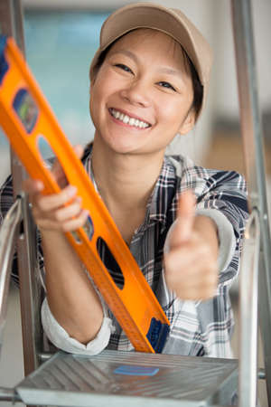 happy female builder showing thumb-upの写真素材