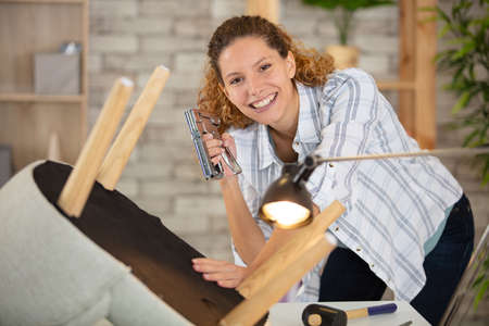 young woman renewing chair smilingの写真素材