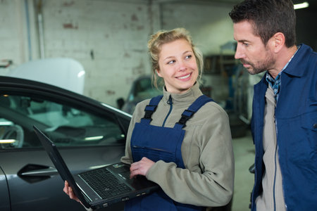 female mechanic with male customer going through maintenance car