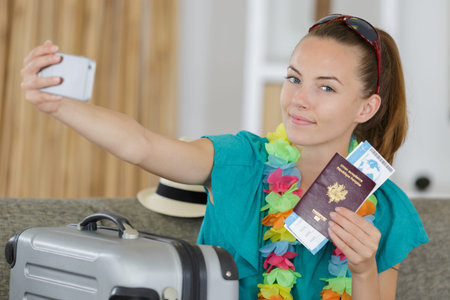 beautiful young tourist girl taking funny selfie with passport