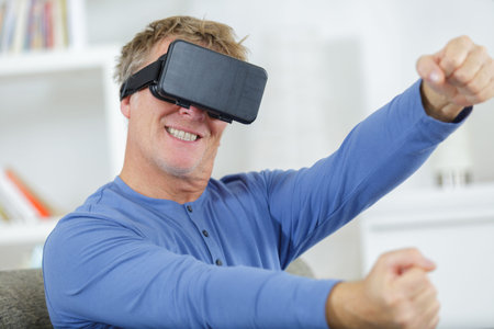 mature man playing driving game wearing virtual reality headset