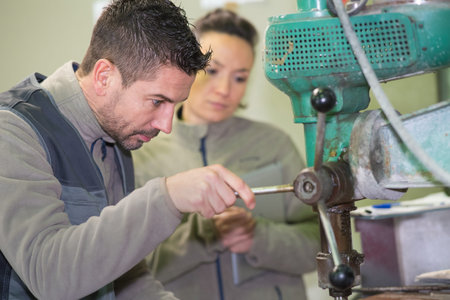 engineer training female apprentice on cnc machine
