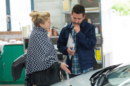 an auto mechanic and female customer in garage