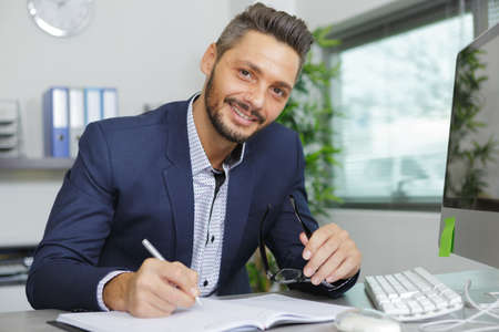 happy young business man portrait in bright modern office indoorの写真素材