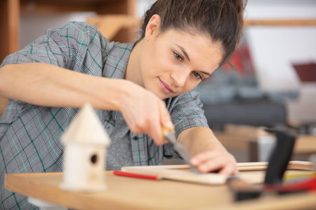 female carpenter working with a chisel in workshop