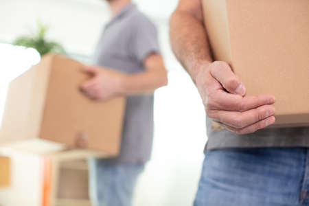 cropped view of removals men carrying boxesの写真素材