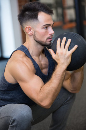 picture of young man holding weight ball