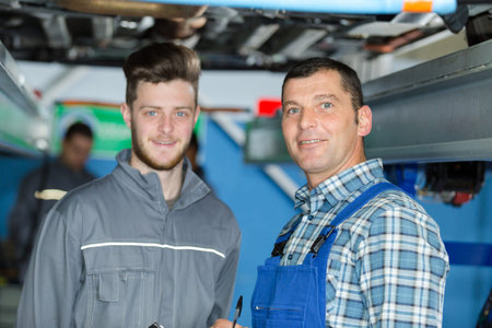 mechanics working under the car in a garage