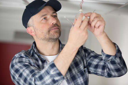 male worker fixing light at homeの写真素材