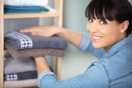 happy woman changing towels in hotel roomの写真素材