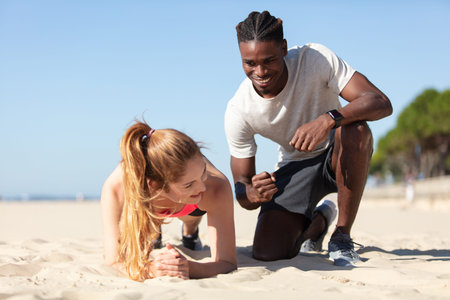 shot of two people exercising on beach in morning
