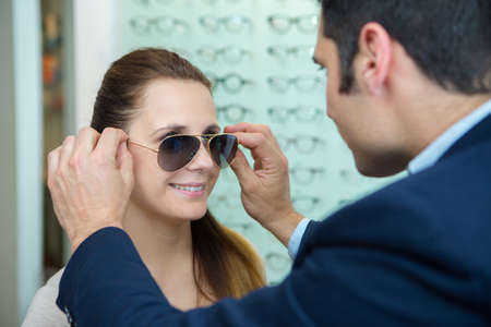 woman with sunglasses smiling and looking at boyfriendの写真素材