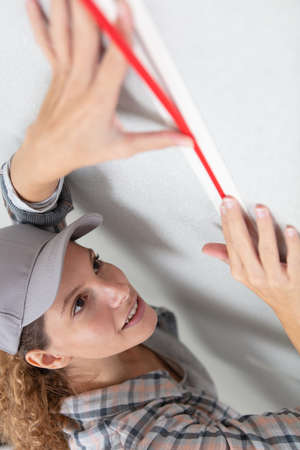 woman with a measure tape working in a construction projectの写真素材