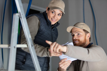 electricians taking measurements in construction site
