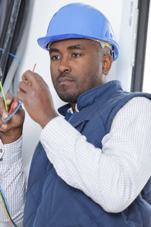 man installing socket on wall at home
