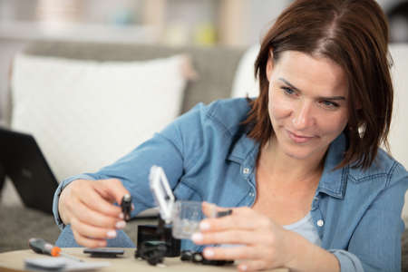 woman is fixing a video cameraの写真素材