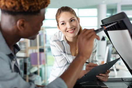 man and woman discussing technical details of printer