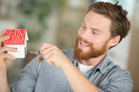 male buyer with paper model of house and keyの写真素材