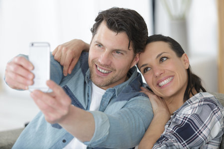 portrait of two happy lovers making selfie on smartphone
