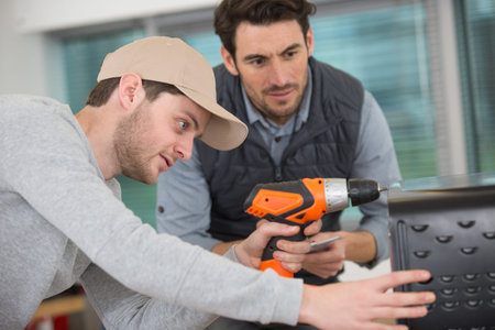 student of a woodworking class learning to drill with nails