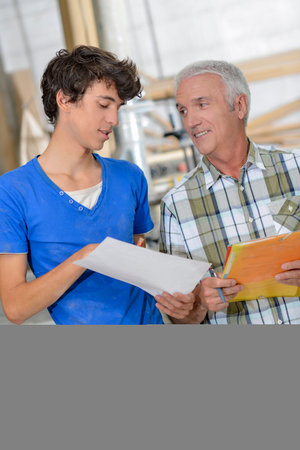 men in the workshop with paper