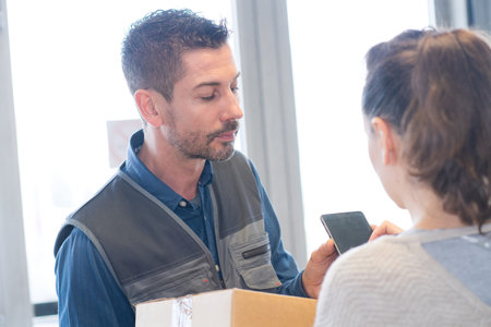 customer making signature of delivery drivers digital device