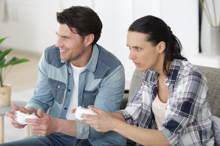 cheerful couple playing video games at home