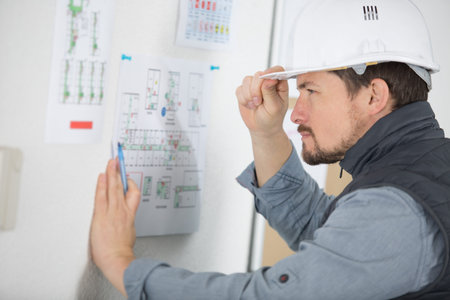 surprised worker reads construction plans