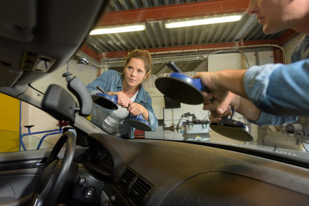 man and woman repairing windshield of the carの写真素材
