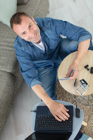 high-angle view of man assembling an action cameraの写真素材