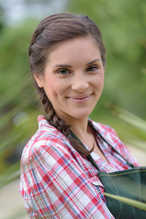 a smiling brunette woman gardeningの写真素材