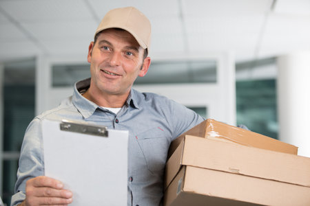 happy man with parcel boxes and clipboardの写真素材