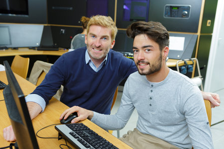 tutor helping mature man in computer classの写真素材