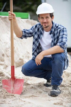 worker builder posing with a shovelの写真素材