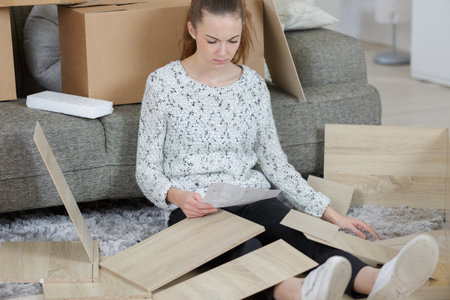a woman assembles a furnitureの写真素材