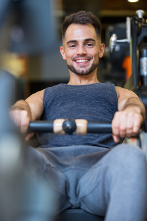 happy man exercising on rowing machine