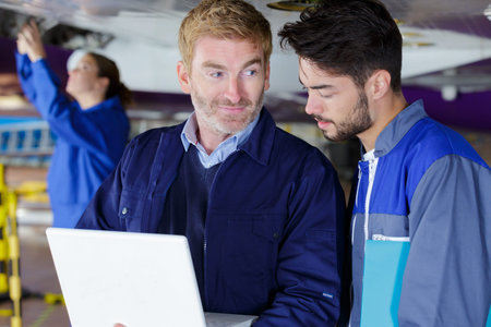 engineering teacher checking airplane engines with his student