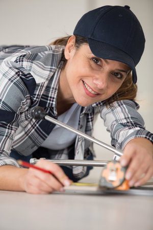 woman knelt down using a tape measureの写真素材