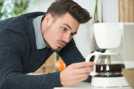 handsome man making coffee with a coffee machineの写真素材
