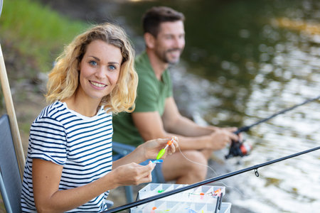 peaceful young couple fishing by the pondの写真素材