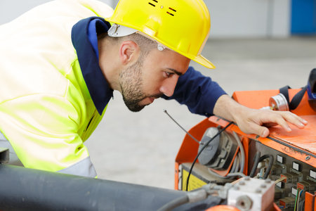 workman starting generator on outdoor site