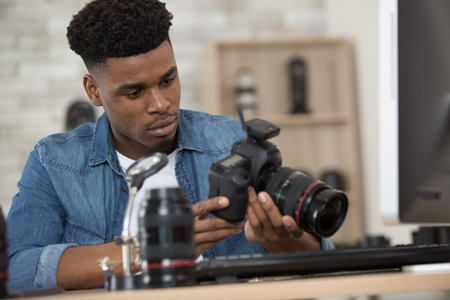 young male repairman repairing his camera