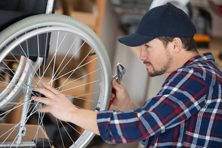 mechanic checking the spokes on a wheelchairの写真素材