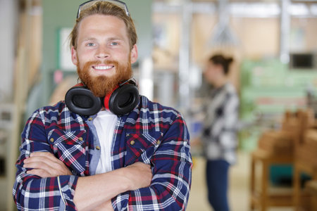 young man with arms crossed smiling at cameraの写真素材