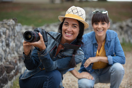 pretty female photographer outdoors with her friendの写真素材