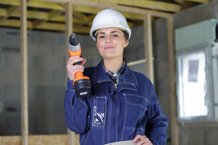 female laborer holding a drilling machineの写真素材