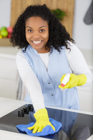 close up of woman cleaning cooker at home kitchen