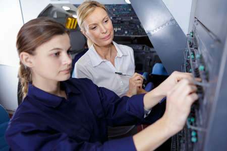 young female apprentice electrician with instructorの写真素材