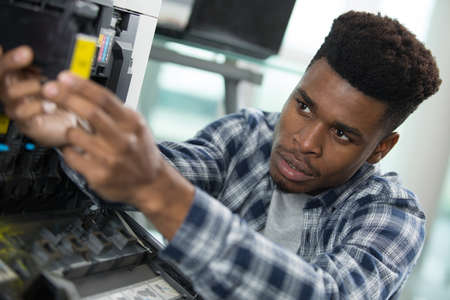 technician holding a screwdriver for fixing printerの写真素材